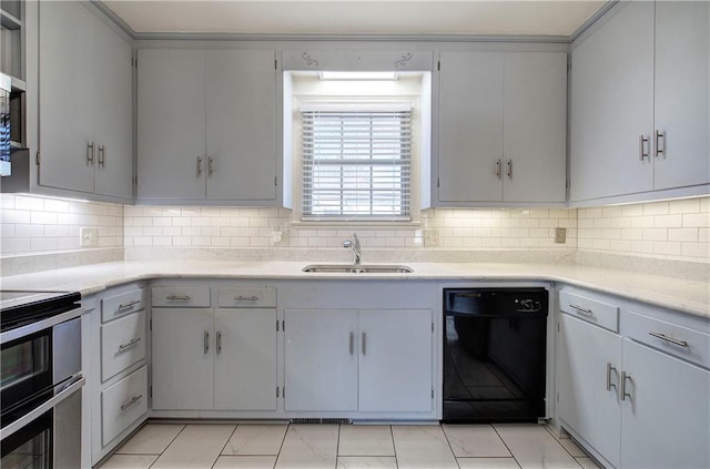 kitchen with gray cabinetry, light countertops, black dishwasher, range with two ovens, and a sink