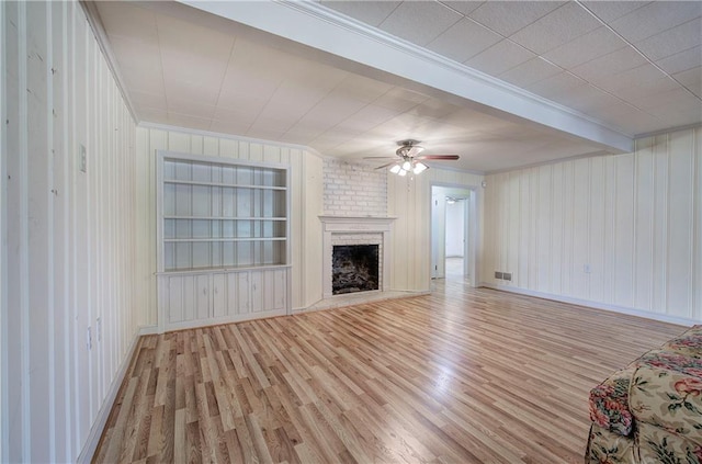 unfurnished living room featuring visible vents, a ceiling fan, built in features, wood finished floors, and a fireplace