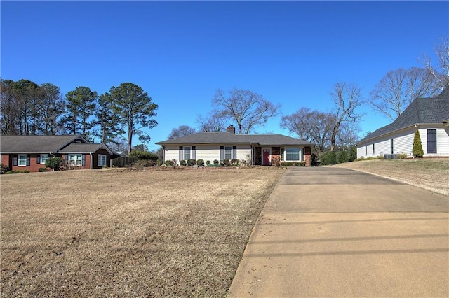 view of front facade with a garage, a chimney, and a front lawn