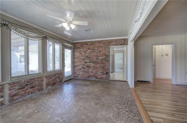 unfurnished living room with visible vents, a sunroom, brick wall, and ornamental molding