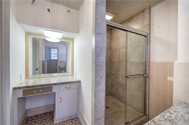 full bath featuring vanity, wooden ceiling, and a stall shower