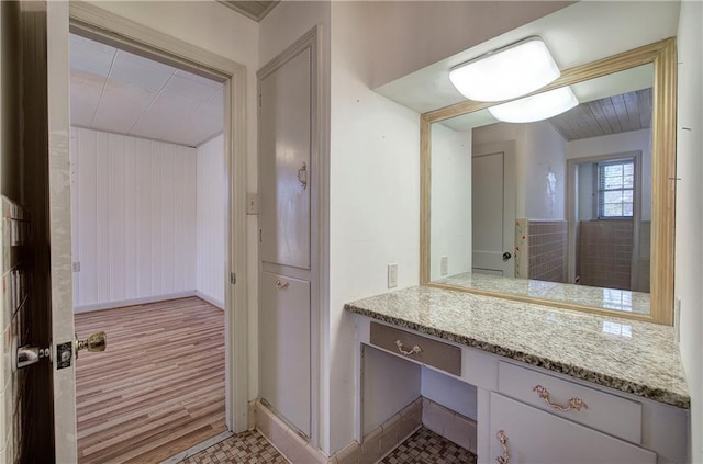 bathroom featuring baseboards, wood finished floors, and vanity