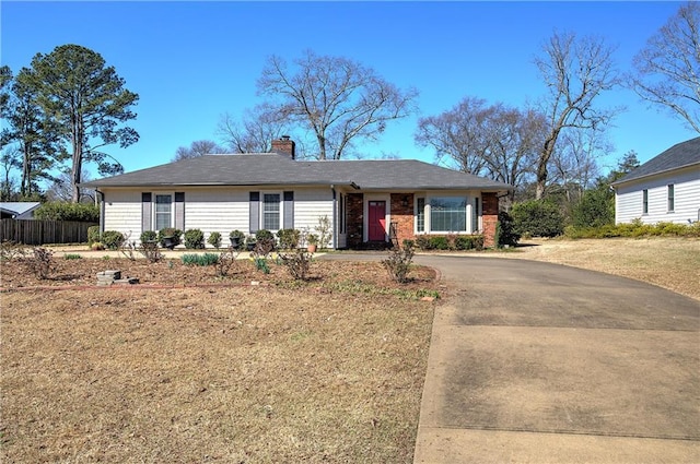 single story home featuring fence, driveway, and a chimney