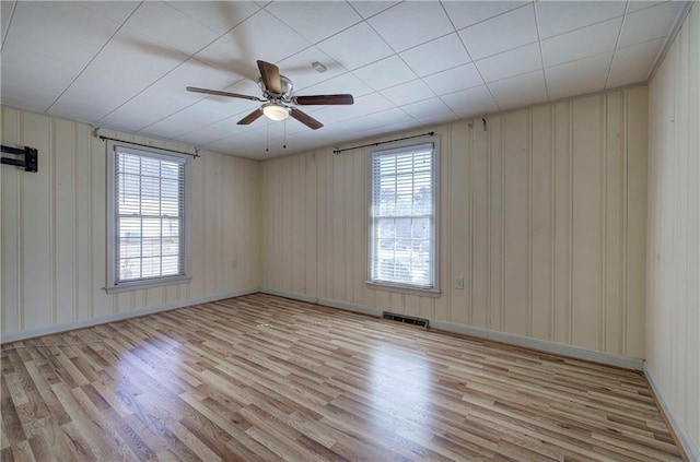 unfurnished room featuring baseboards, visible vents, light wood-type flooring, and ceiling fan