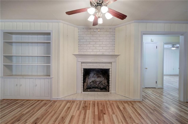 unfurnished living room with crown molding, wood finished floors, and a fireplace