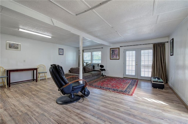 living room with french doors, baseboards, and wood finished floors