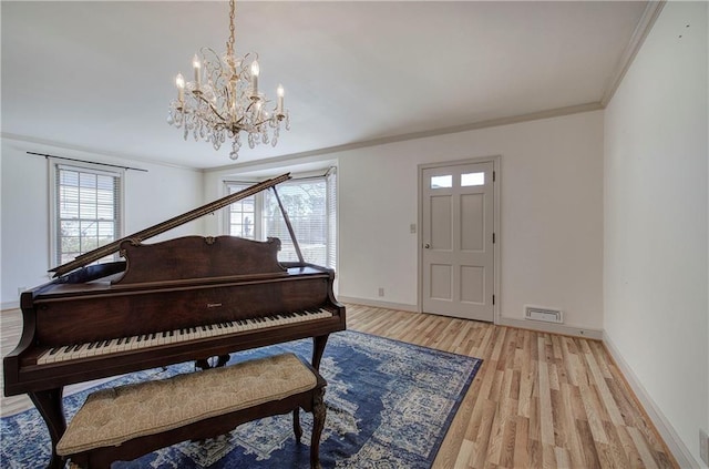 foyer featuring a healthy amount of sunlight, light wood-style floors, and ornamental molding