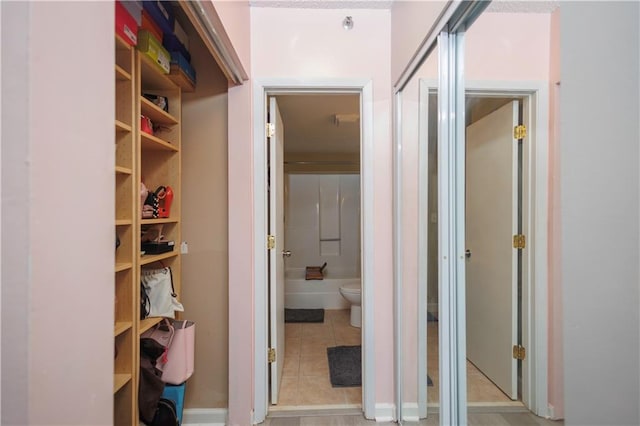 hall with light tile patterned floors