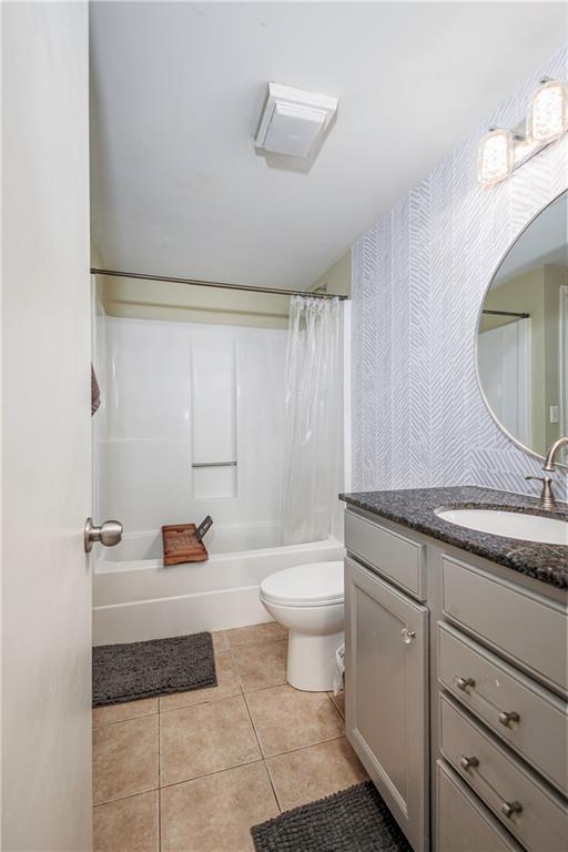 full bathroom with toilet, vanity, tile patterned floors, and shower / bath combination with curtain