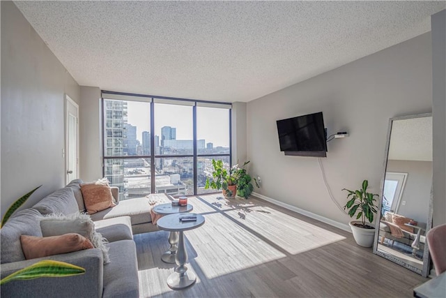 living room with a textured ceiling, floor to ceiling windows, and hardwood / wood-style floors