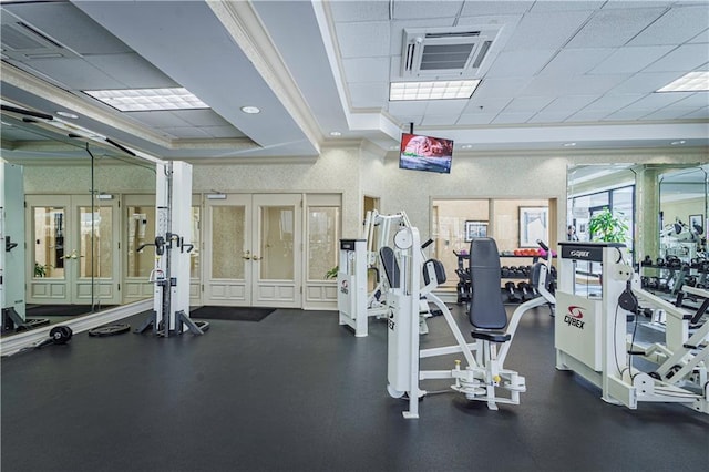 workout area with a tray ceiling, a paneled ceiling, and french doors