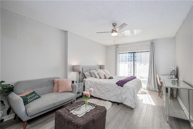 bedroom with ceiling fan, a textured ceiling, and hardwood / wood-style flooring