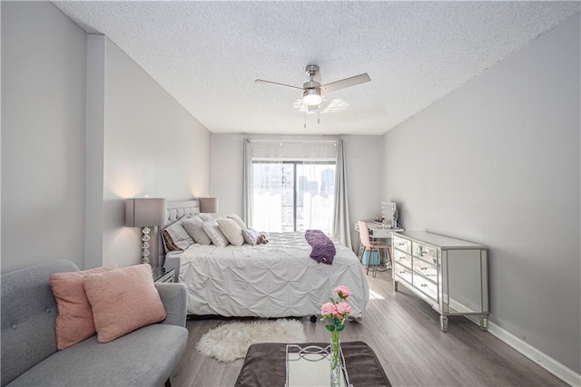 bedroom featuring a textured ceiling, ceiling fan, and hardwood / wood-style floors