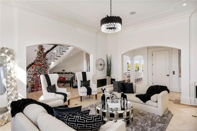 living room with an inviting chandelier and ornamental molding