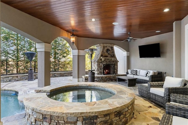 exterior space featuring an outdoor stone fireplace and ceiling fan