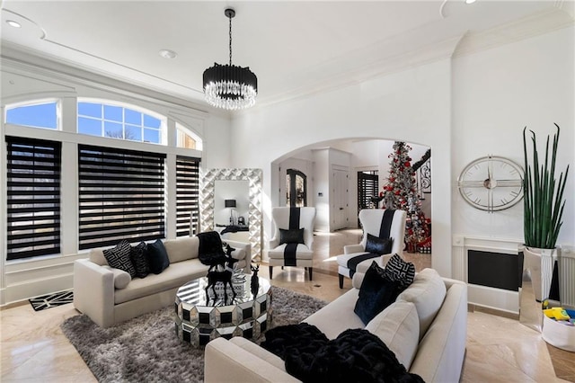 living room with crown molding and a chandelier