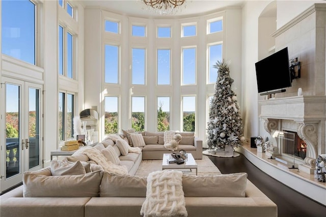 living room with french doors, a high ceiling, and a premium fireplace