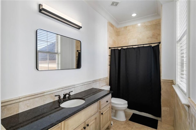 bathroom with a shower with curtain, crown molding, toilet, vanity, and tile walls