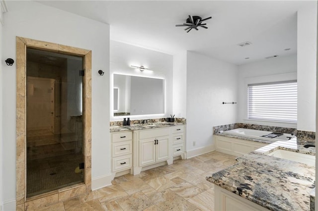 bathroom featuring vanity and independent shower and bath