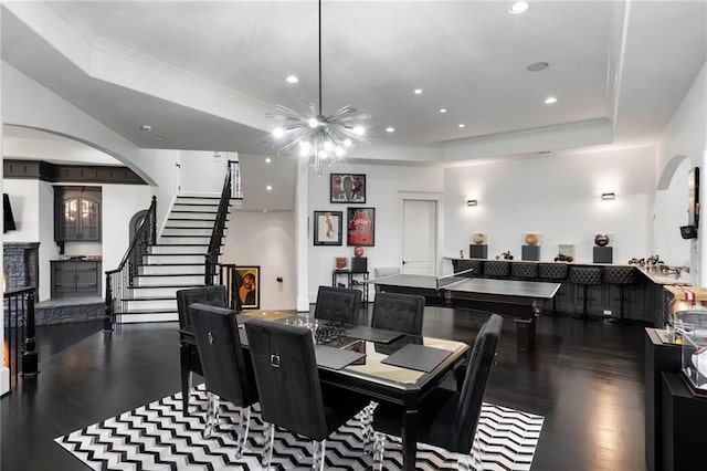 dining room featuring a tray ceiling, crown molding, dark hardwood / wood-style flooring, and a chandelier