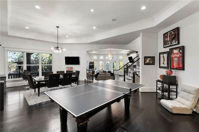 recreation room featuring a raised ceiling, dark hardwood / wood-style flooring, and a notable chandelier