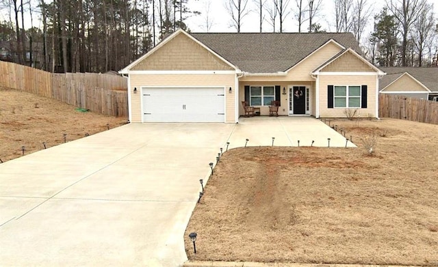 view of front of home featuring driveway, a garage, and fence