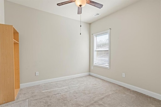 empty room featuring baseboards, a ceiling fan, visible vents, and carpet floors