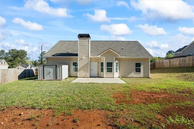 rear view of house featuring a shed, a yard, a fenced backyard, a patio, and an outbuilding