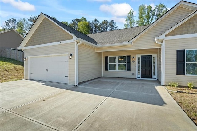 view of front facade featuring concrete driveway, roof with shingles, and a garage