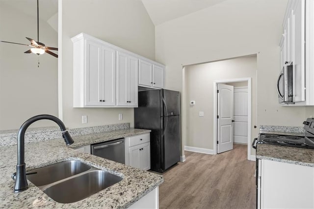 kitchen with appliances with stainless steel finishes, white cabinets, lofted ceiling, a sink, and ceiling fan