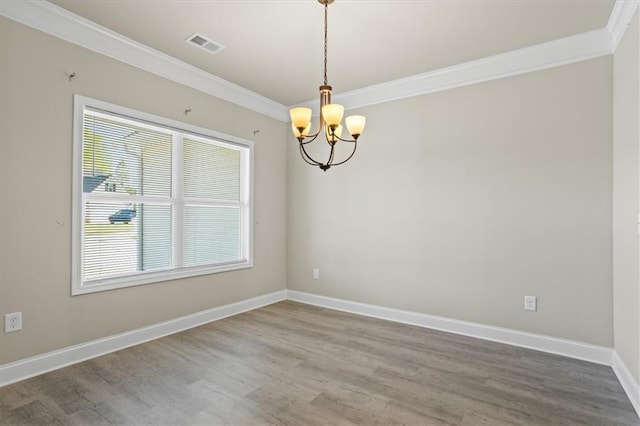 empty room with ornamental molding, visible vents, baseboards, and a chandelier