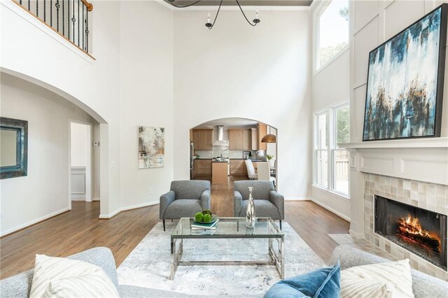 1096 Bridge Mill Ave, Canton, GA 30114 - living area featuring a towering ceiling, wood finished floors, arched walkways, a fireplace, and baseboards