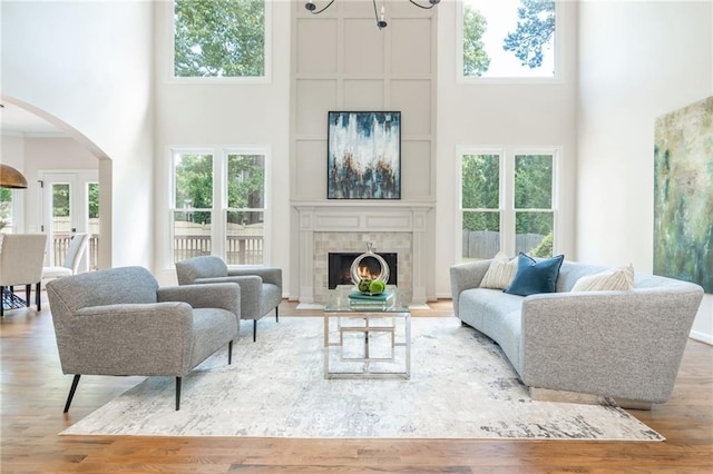 1096 Bridge Mill Ave, Canton, GA 30114 - living room featuring a towering ceiling, arched walkways, wood finished floors, and a tiled fireplace