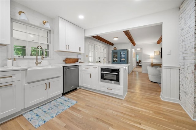 1104 Warrenhall Ln NE, Brookhaven, GA 30319 - kitchen with appliances with stainless steel finishes, beamed ceiling, white cabinetry, light wood-style floors, and light countertops