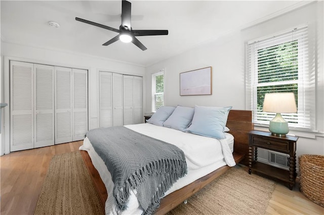 1104 Warrenhall Ln NE, Brookhaven, GA 30319 - bedroom featuring two closets, light wood-type flooring, a ceiling fan, and ornamental molding