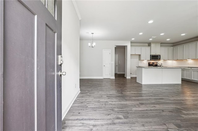 791 Belrose Dr, Smyrna, GA 30080 - kitchen with stainless steel microwave, baseboards, wood finished floors, stove, and a chandelier