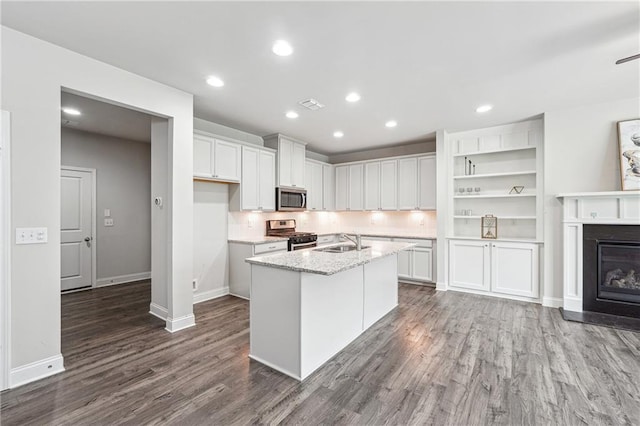 791 Belrose Dr, Smyrna, GA 30080 - kitchen featuring appliances with stainless steel finishes, a sink, dark wood-type flooring, white cabinets, and a center island with sink