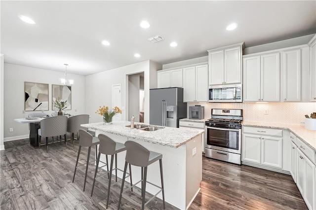 791 Belrose Dr, Smyrna, GA 30080 - kitchen with stainless steel appliances, dark wood-style floors, a center island with sink, a sink, and white cabinetry