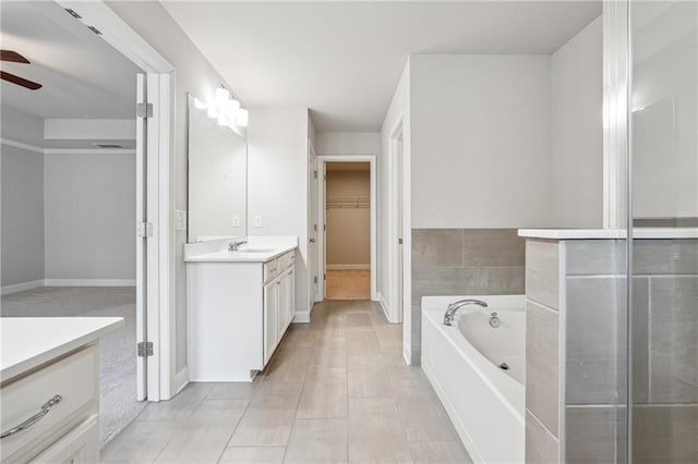 791 Belrose Dr, Smyrna, GA 30080 - bathroom featuring vanity, ceiling fan, a garden tub, a spacious closet, and baseboards