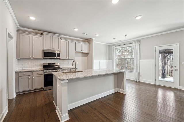 kitchen with gray cabinetry, stainless steel appliances, a sink, dark wood-style floors, and crown molding