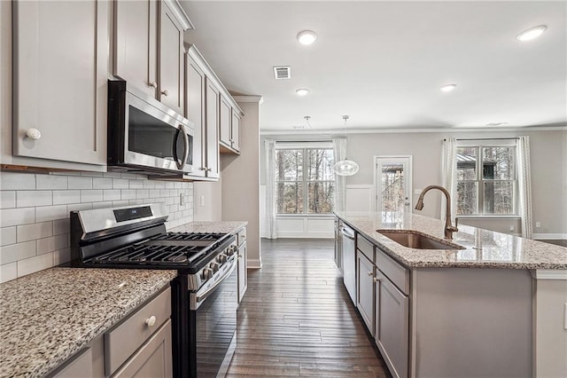 kitchen with visible vents, appliances with stainless steel finishes, ornamental molding, dark wood-type flooring, and a sink