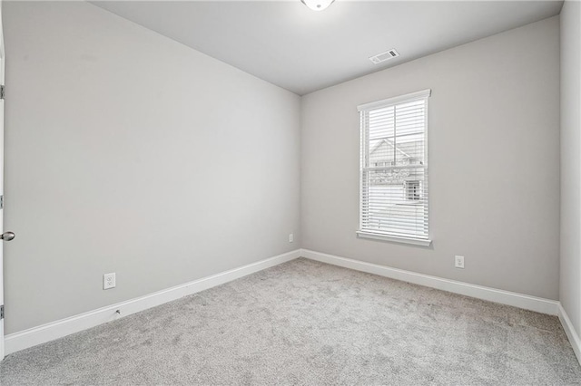 carpeted empty room featuring baseboards and visible vents