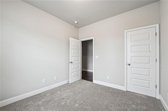 unfurnished bedroom with carpet floors and baseboards