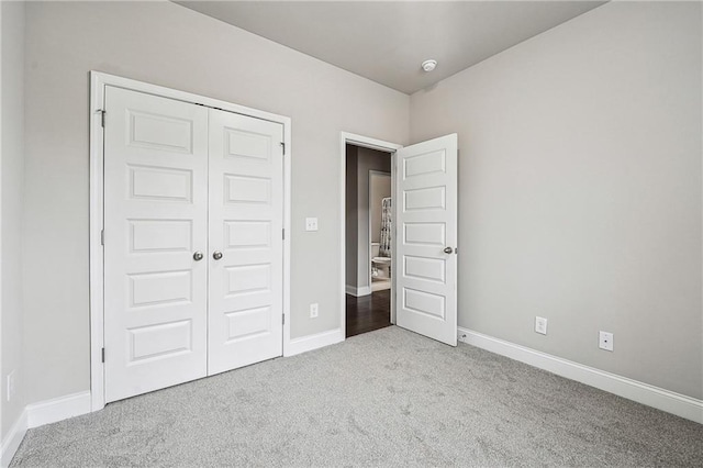 unfurnished bedroom featuring carpet floors, baseboards, and a closet