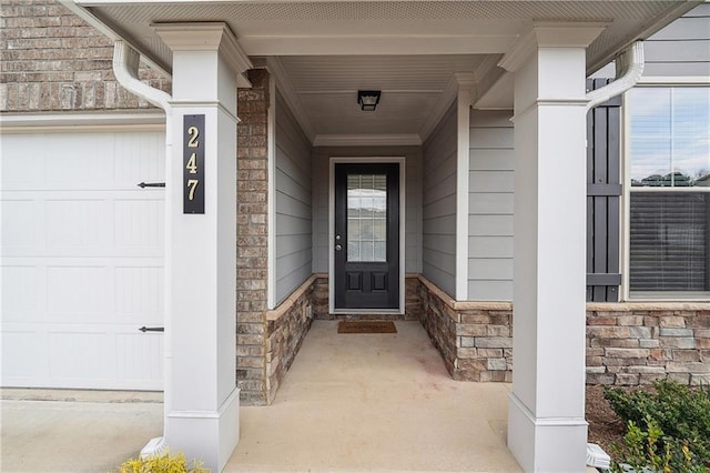 doorway to property with stone siding and an attached garage