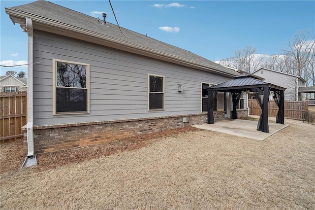 back of property with a patio area, fence, brick siding, and a gazebo