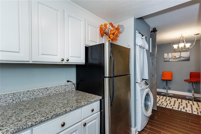 kitchen featuring washer / clothes dryer, freestanding refrigerator, dark wood-style floors, white cabinets, and baseboards
