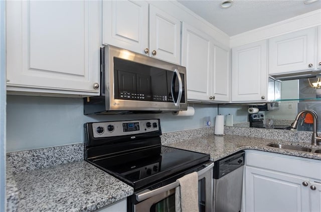 kitchen with stainless steel appliances, a sink, white cabinetry, and light stone counters