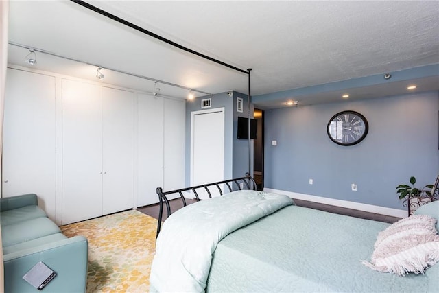 bedroom with track lighting, a closet, recessed lighting, and baseboards