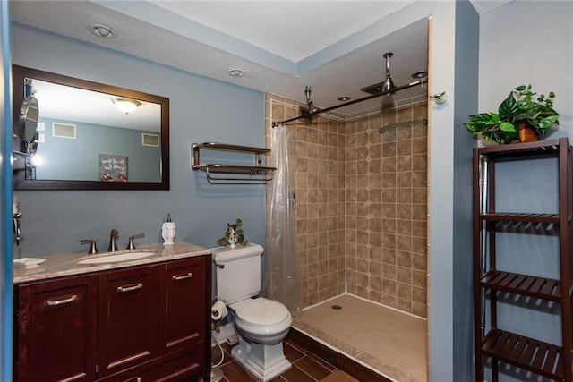 full bath with tiled shower, toilet, and vanity